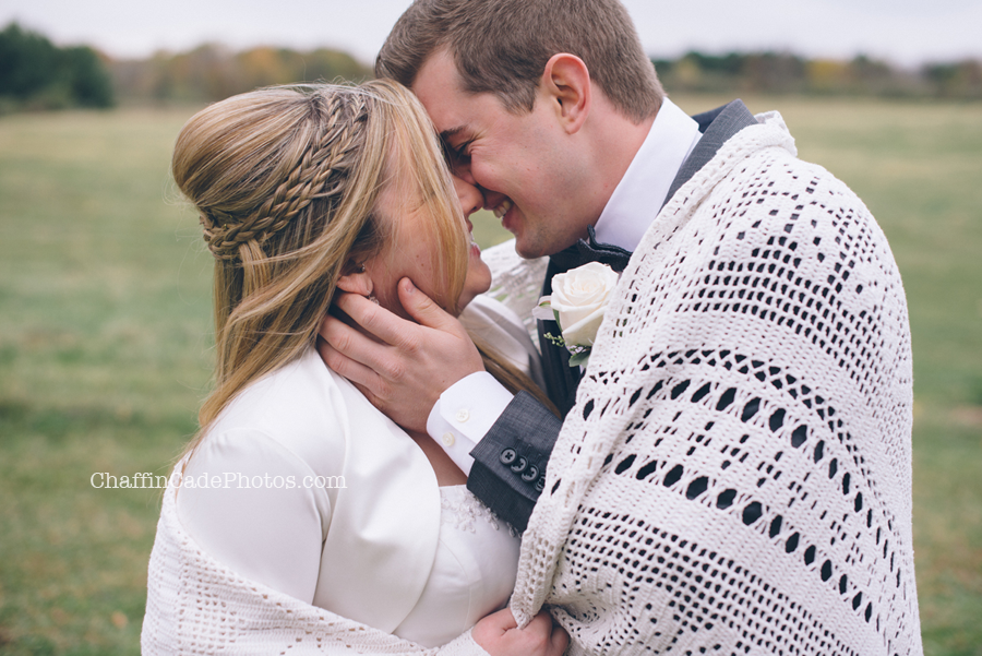 a close up of Ginger and Mike snuggling up in a vintage quilt, as they laugh and kiss